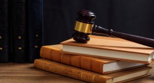Judge gavel on law books, wooden desk